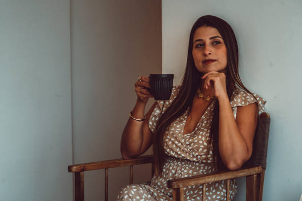 istock Beautiful model smiling and drinking coffee from a black mug in a beautiful minimalist architecture apartment 2166236866