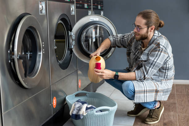 istock Household-conscious male using automatic washer at laundry service 2166238362