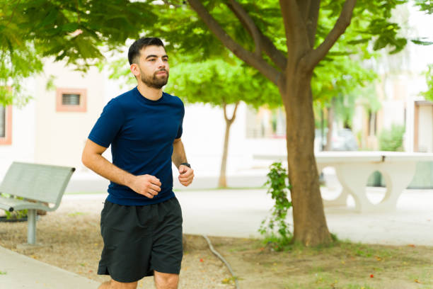 istock Focused and determined young man embracing an active lifestyle while jogging in a sunny park, enjoying the fresh air and green surroundings 2166242828