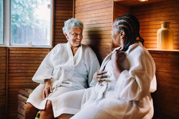 Two mature women inside a sauna having conversations in a spa