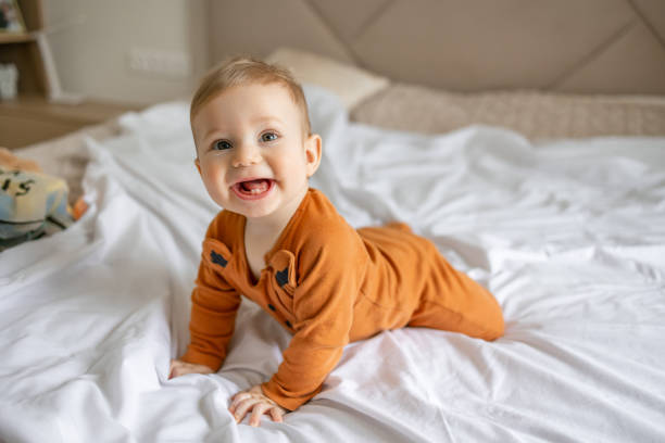 Smiling Baby Crawling On Bed In Cozy Home
