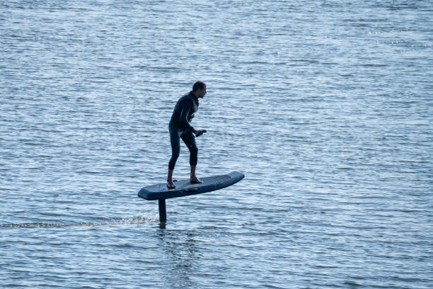 istock Surfer glides above calm water on electric hydrofoil board 2166249449