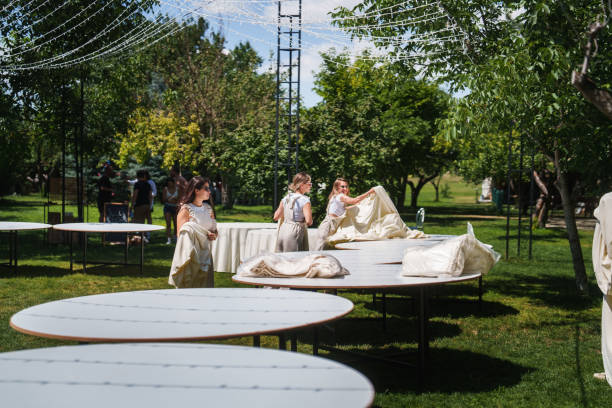 istock The wedding planning team is setting tablecloths on the tables for the wedding dinner. 2166254355