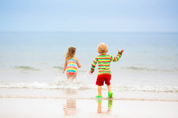 istock Kids playing on beach. Children play at sea. 2166256191