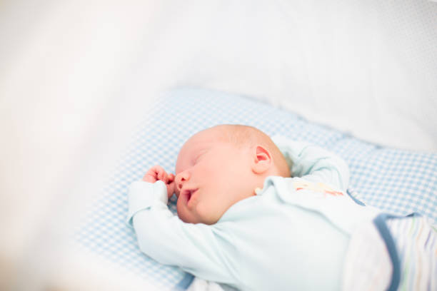 istock Little baby on white bed 2166257004