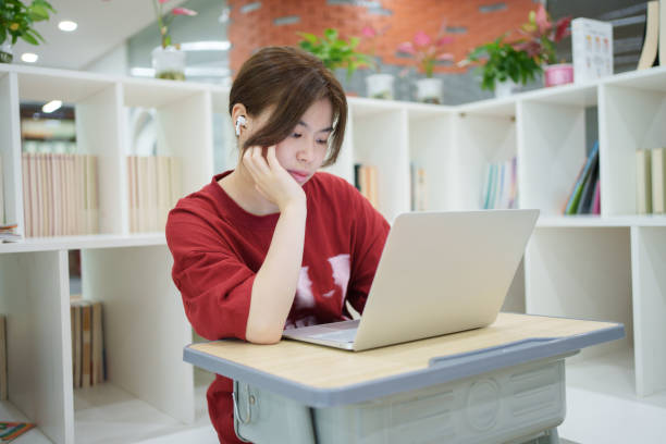 Asian female student using laptop to surf the Internet