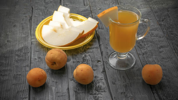 istock Fresh Summer Snack: Sliced Melon and Apricots with Refreshing Beverage on Rustic Wooden Table 2166262672