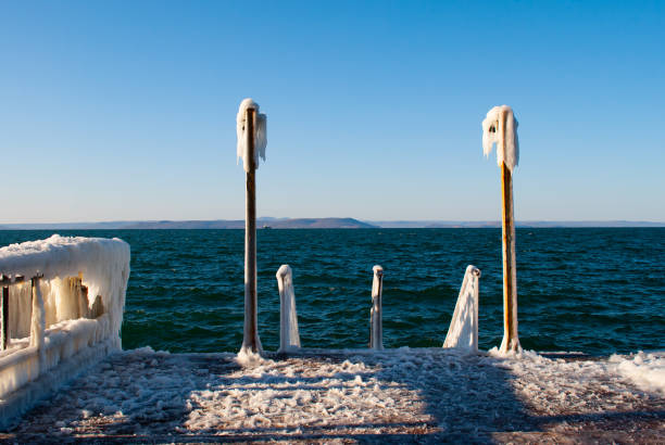 A beautiful shot of an icy frozen shore of the lake during frosty wintertime.