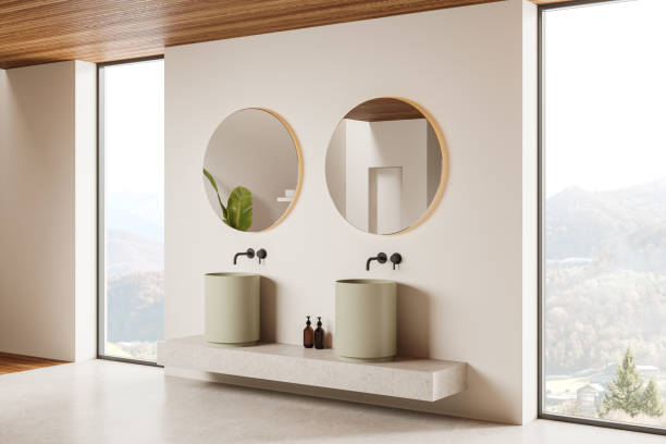 istock Beige hotel bathroom interior with double sink and accessories, window 2166279599