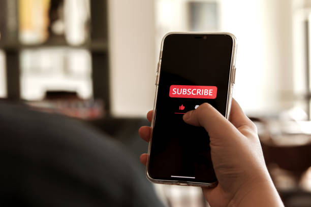 istock Close-up view of men using a smartphone to press red subscribe button on online media. 2166282966