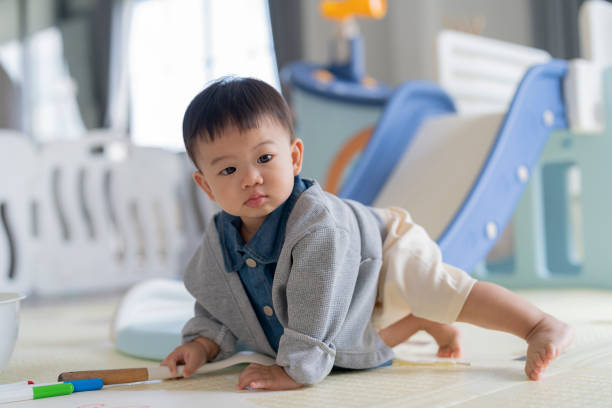 istock Relaxing Asian baby boy sit relax lying down and enjoy to using maker color drawing picture on drawing paper at home Little boy drawing on the floor 2166283830