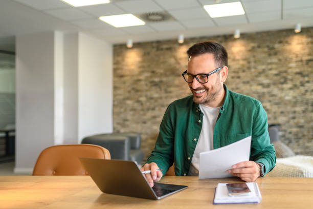 istock Portrait of handsome manager analyzing financial reports over computer at his workplace in modern office 2166286883