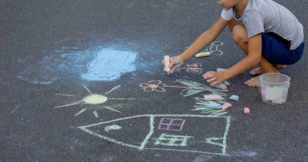 istock the boy draws with chalk on the asphalt. Selective focus 2166287964