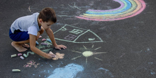 istock the boy draws with chalk on the asphalt. Selective focus 2166287967