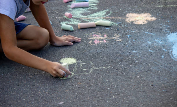 istock the boy draws with chalk on the asphalt. Selective focus 2166287968