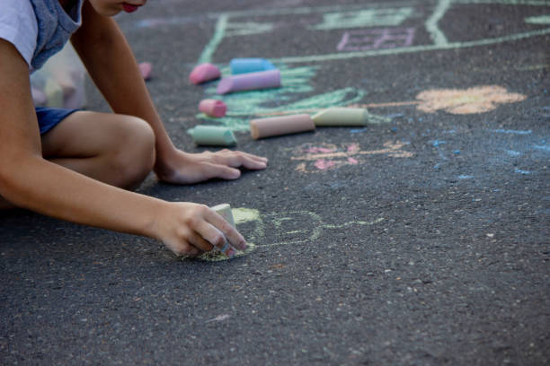 istock the boy draws with chalk on the asphalt. Selective focus 2166287970