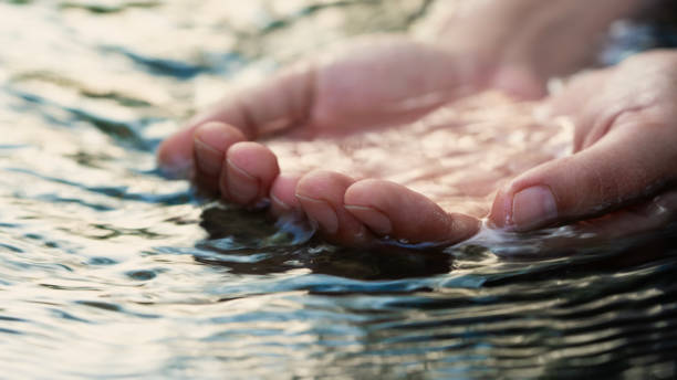 istock A female hand touching the river water 2166290170