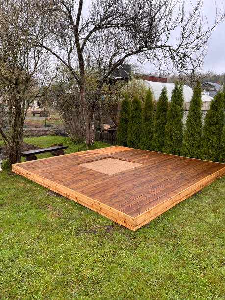 istock Finished wooden deck with central cut-out in a landscaped backyard surrounded by greenery. 2166294293