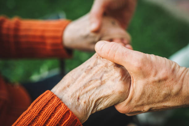 istock Close-up of a man holding an elderly woman's hands 2166296480