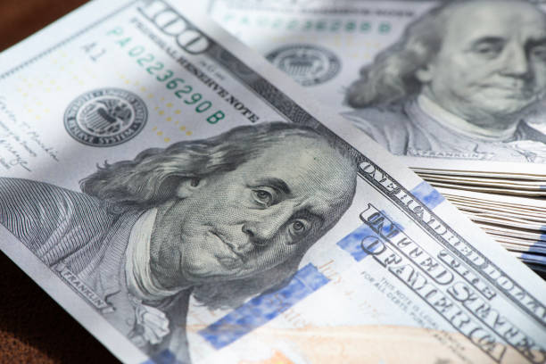 istock Stack of one hundred dollar banknotes close up with selective focus 2166299739