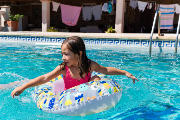 istock Girl having fun playing in a swimming pool with inflatable ring 2166300198