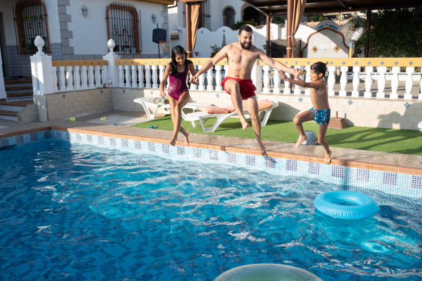 istock Father jumping in swimming pool 2166300200