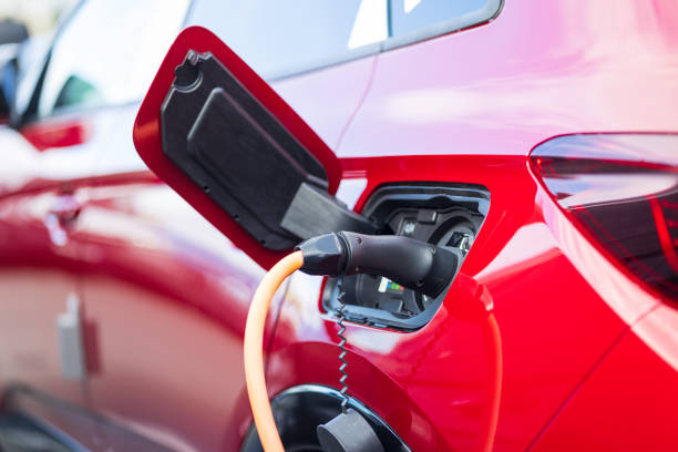 istock red electric car charging at charging station 2166303023