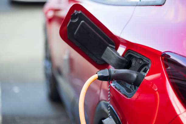istock red electric car charging at charging station 2166303025
