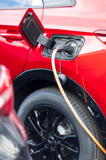 istock red electric car charging at charging station 2166303026