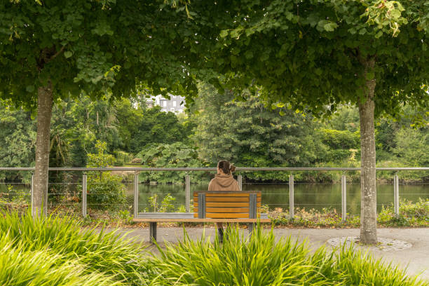 istock Woman sitting on a bench. 2166303626