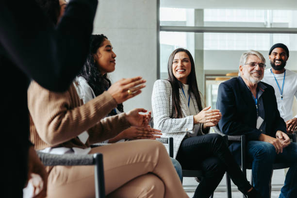 istock Interactive corporate dialogue: Diverse professionals engaged in discussion and applause 2166303687