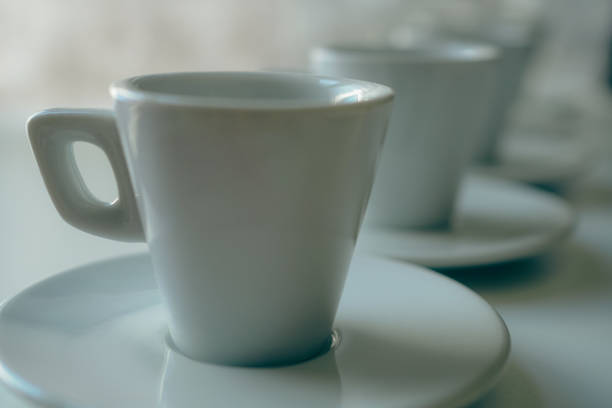 Closeup of White coffee cups and saucers arranged on a white table
