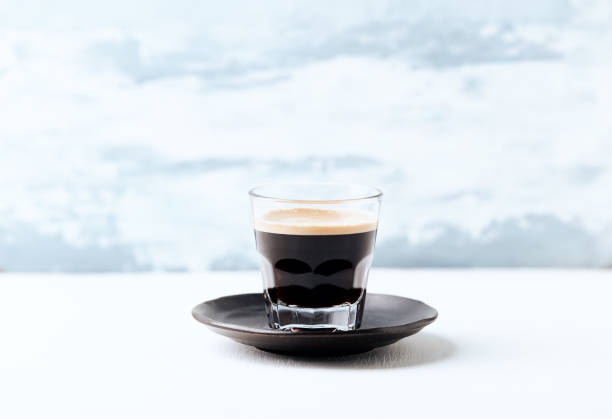 istock Coffee in glass cup on bright wooden background. Copy space. 2166309270
