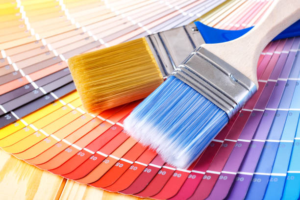istock Painter and decorator work table with house project, color swatches, painting roller and paint brushes 2166311687