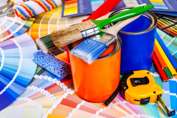 istock Painter and decorator work table with house project, color swatches, painting roller and paint brushes 2166311690