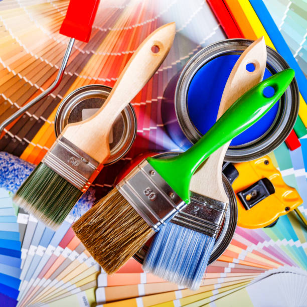 istock Painter and decorator work table with house project, color swatches, painting roller and paint brushes 2166311706