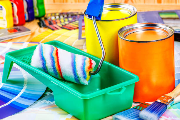 istock Painter and decorator work table with house project, color swatches, painting roller and paint brushes 2166311718