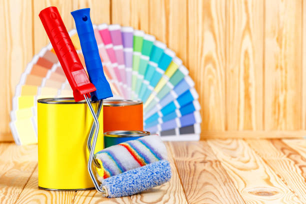 istock Painter and decorator work table with house project, color swatches, painting roller and paint brushes 2166311745