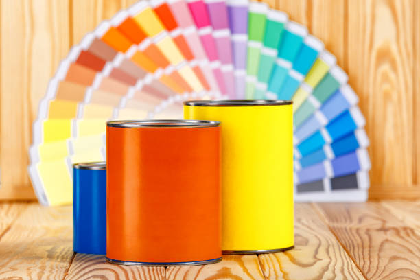 Cans of interior wall paint is placed on a red background.