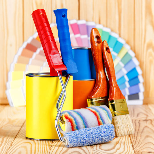 istock Painter and decorator work table with house project, color swatches, painting roller and paint brushes 2166311747