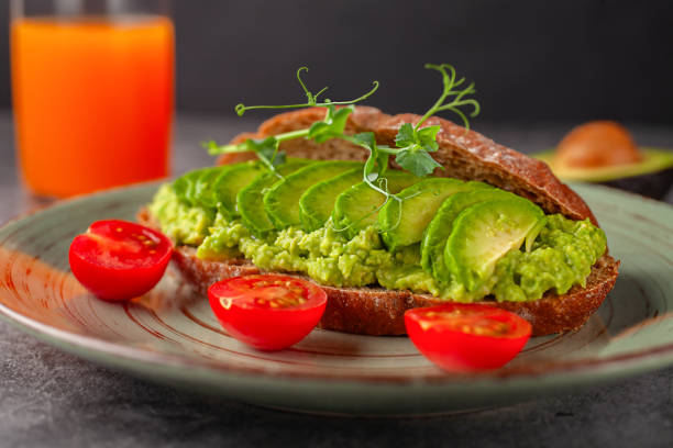 istock Vegan sandwich with avocado and tomatoes on a plate, on a gray background 2166316384