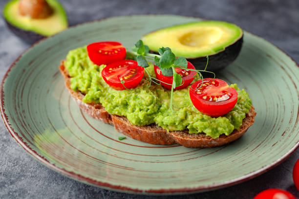 istock Vegan sandwich with avocado and tomatoes on a plate, on a gray background 2166316512