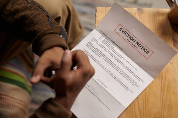 istock Person Reading Eviction Notice at Wooden Table 2166322998