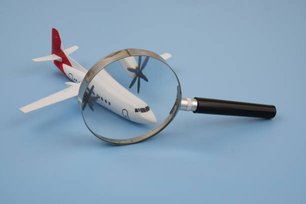 istock Airplane under magnifying glass on blue background. 2166324958