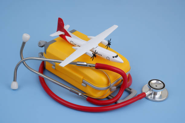 istock Airplane on suitcase and stethoscope on blue background. 2166325603
