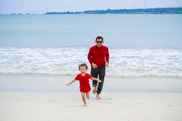 single parent and son playing on the beach