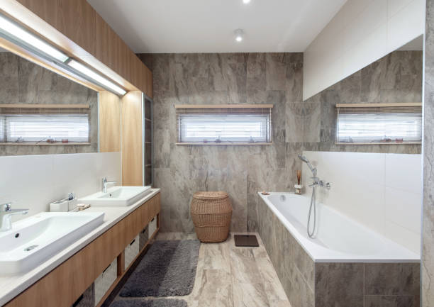 istock Bright Elegant Modern Bathroom Interior Design of White Bath, Sink, Mirror. Bathroom Accessories, Gray Tile Walls, LED Light. 2166331027