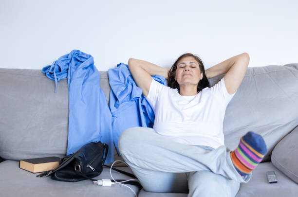 nurse medical worker resting and taking a break sitting cross-legged on the sofa after work.middle eastern woman doctor smiling breathing in mindfulness and meditation.