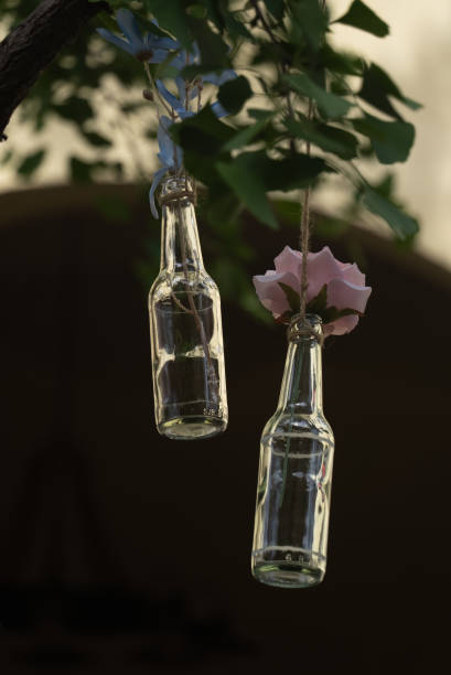 istock bottles with flower hanging on tree 2166335479