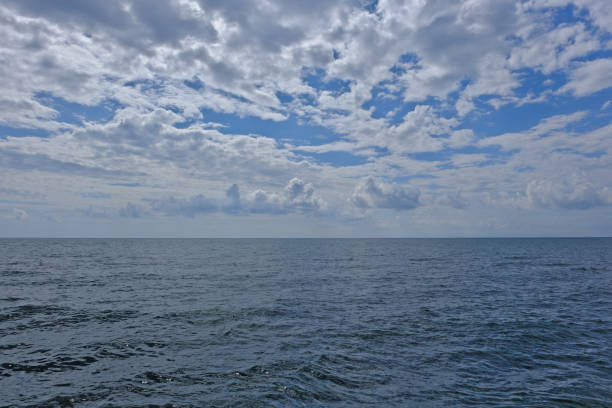 blue sky and white clouds over the calm sea surface. Beautiful seascape.